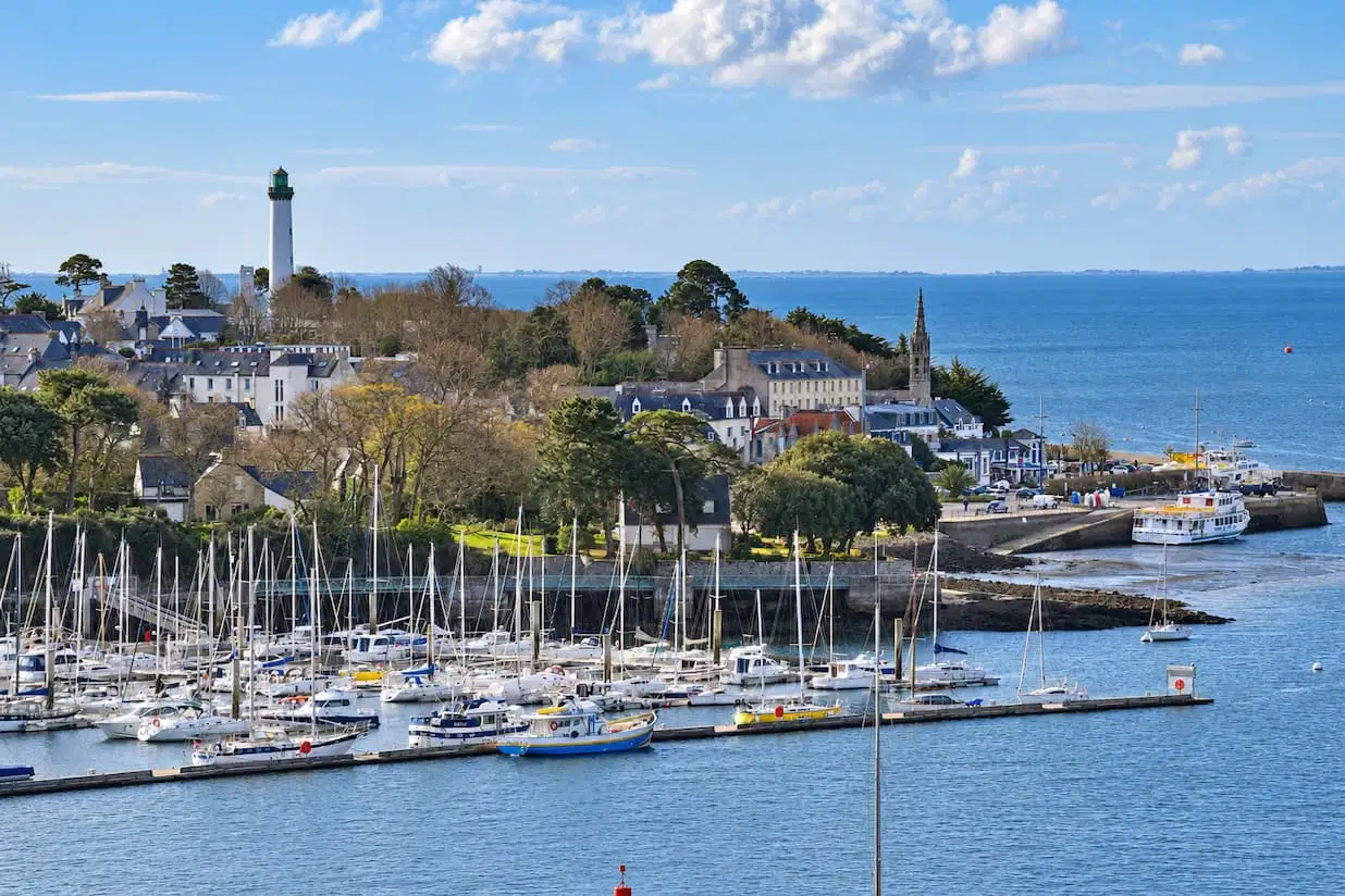 Port de plaisance avec voiliers, phare et maisons en bord de mer